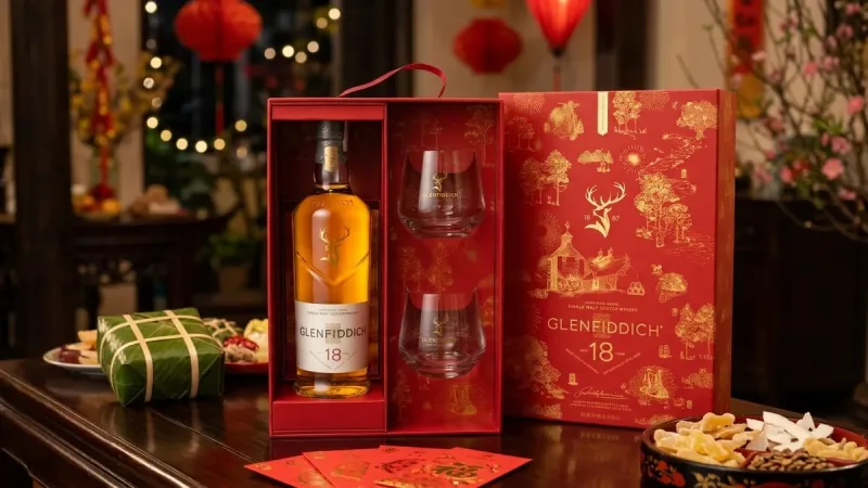 Hộp quà Glenfiddich 18 năm Tết 2027 màu đỏ mở nắp bên bánh chưng và bao lì xì