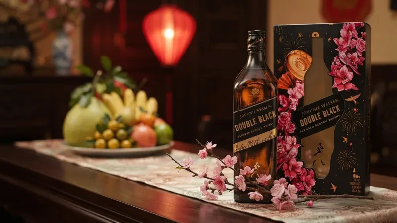 Rượu Johnnie Walker Double Black 1L Hộp Quà Tết 2027 bên cành đào hồng